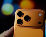 iPhone 17 Pro Max in cosmic orange held in hand, camera close-up, photographed at Walker Wireless