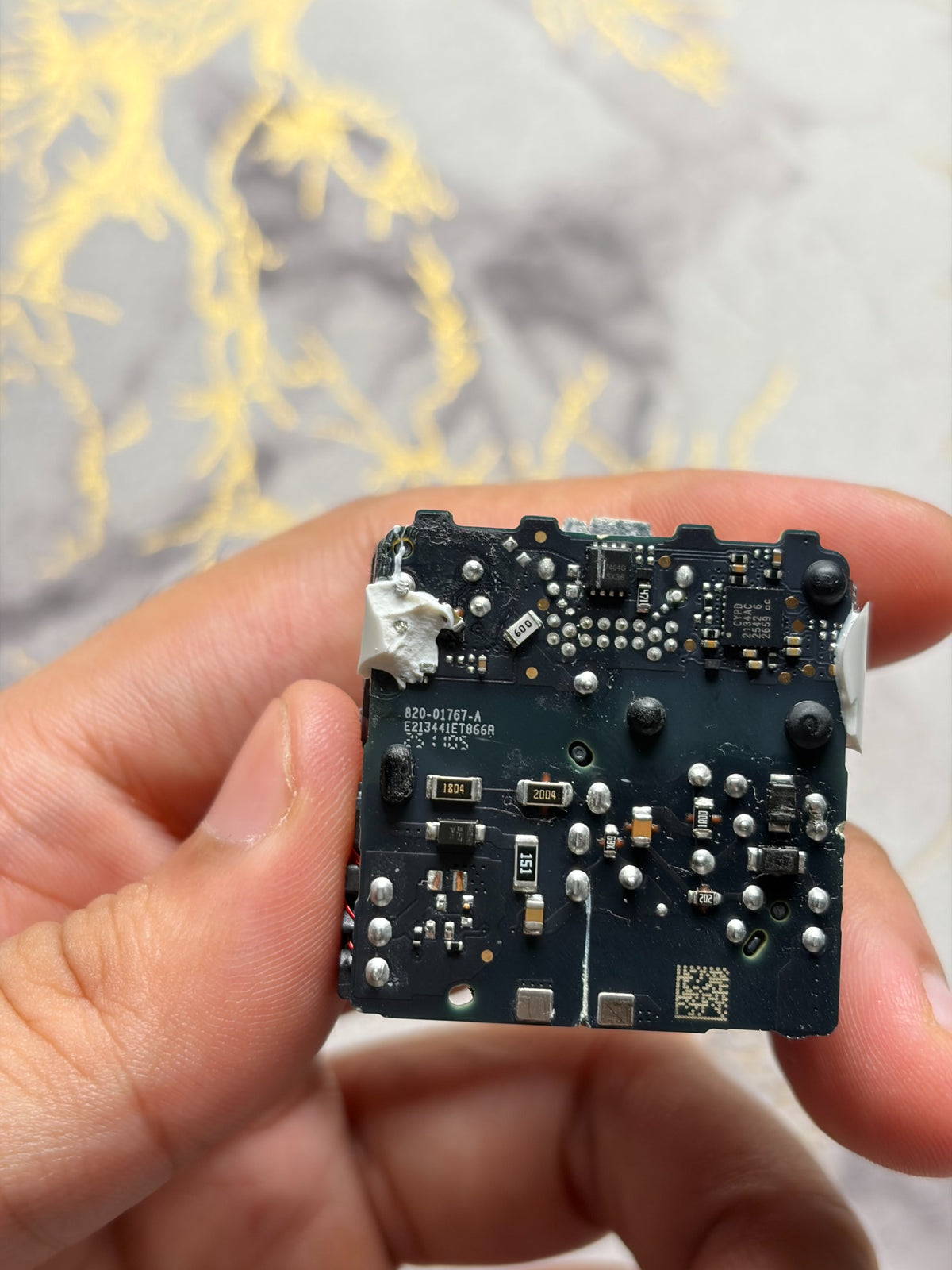 Teardown reference photo of an opened Apple 20W adapter sample - circuit board underside; units sold are new and box packed